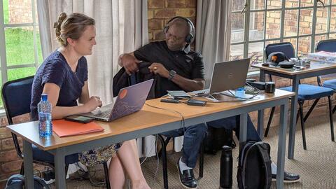 Emilee and Francis observing from the back of the meeting room
